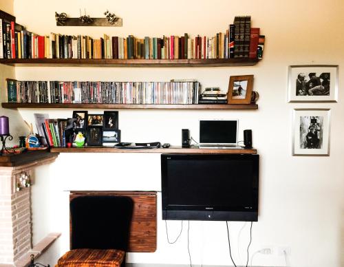 einen Schreibtisch mit einem Computer und einem Monitor an der Wand in der Unterkunft UMBRIA, "Casa Sagrantina" con PISCINA e pergolato in Collazzone