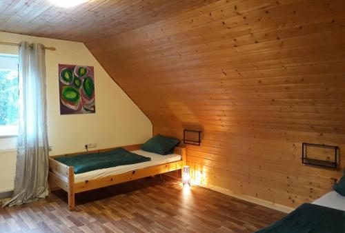 メッケンベウーレンにあるFerienwohnung Danielaの木製の壁のドミトリールームのベッド1台分です。