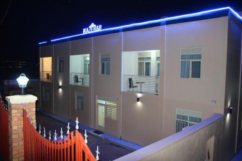 a building with an orange fence in front of it at night at Ikaze B&B in Kigali