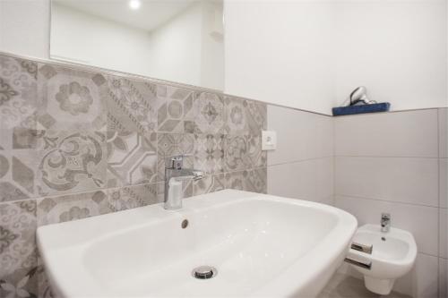 a bathroom with a white sink and a toilet at Residenza Picalof in Nago-Torbole