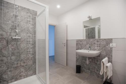 a white bathroom with a sink and a shower at Residenza Picalof in Nago-Torbole