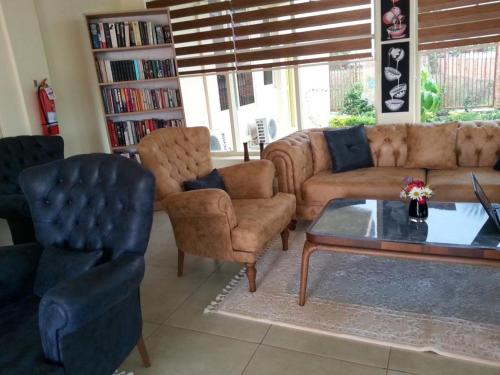 a living room with a couch and chairs and a table at Ikaze B&B in Kigali