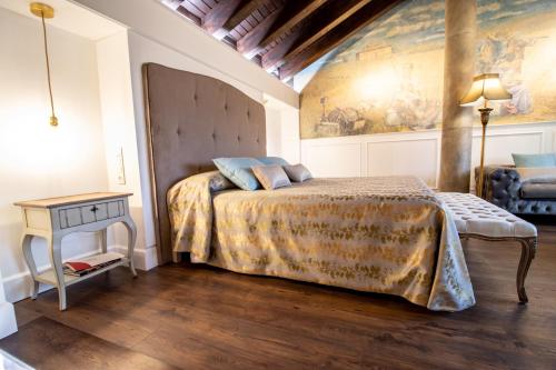 a bedroom with a bed and a painting on the wall at Posada Los Condestables Hotel & Spa in Villalpando