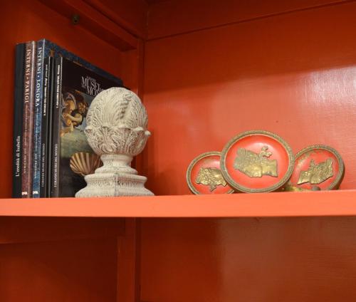a shelf with books and a statue on it at Piano8 in Asola