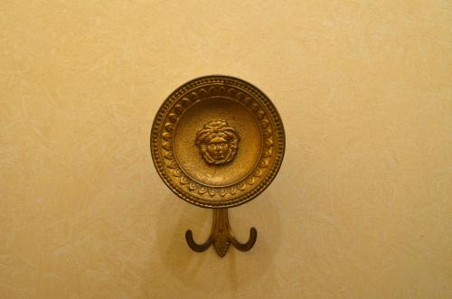 a gold mirror on a wall with a lion on it at Piano8 in Asola