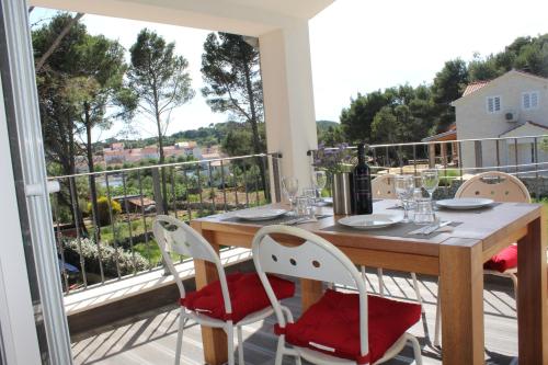 VerunićにあるGorgonia Suites in Verunicの木製テーブルと椅子付きのバルコニーから眺めの良い景色を楽しめます。