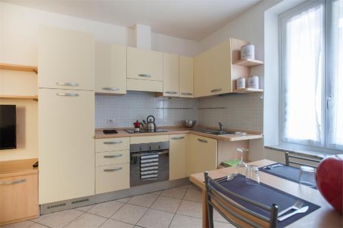 a kitchen with white cabinets and a sink at Residenza Picalof in Nago-Torbole