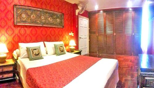 a bedroom with a bed and a red wall at Amazing Tropical Family Thai Style Villa all costs included in Pattaya South