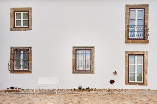 a white chair sitting in front of a white building at Convento do Seixo Boutique Hotel & Spa in Fundão