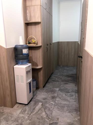 a small room with a small refrigerator and wooden cabinets at EXPO Hotel Comfort in Kyiv