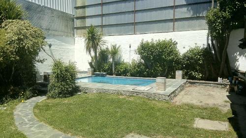聖卡洛斯－德巴里洛切的住宿－Universal Traveller's Hostel，一座游泳池,位于一座建筑旁的院子内