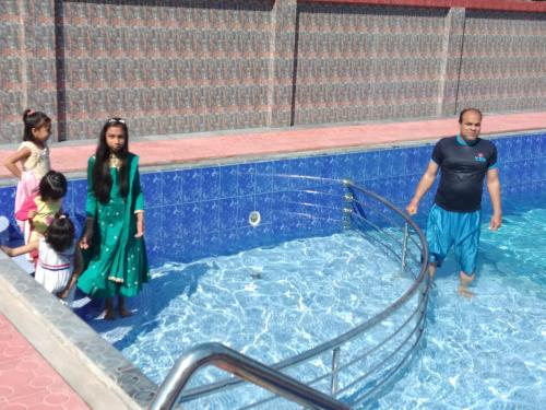 a group of people standing in a swimming pool at Grand Selim Resort & Tour – GSRT in Sreemangal