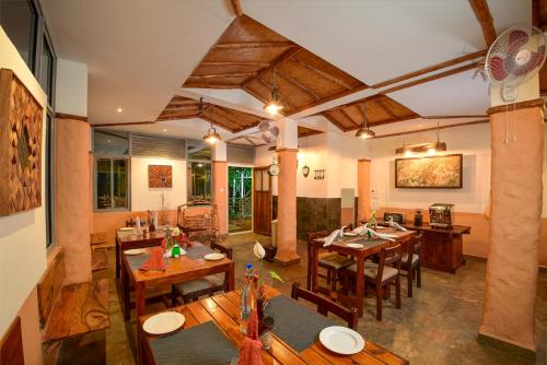 una sala da pranzo con tavoli e sedie in legno di Mistletoe Homestay & Cafe a Munnar