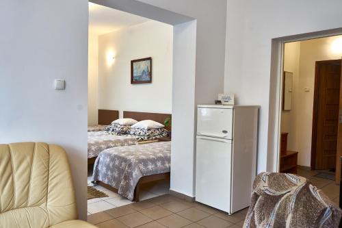 Zimmer mit 2 Betten und einem weißen Kühlschrank in der Unterkunft Apartamenty Lord in Świecie