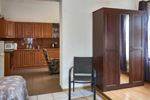 una cocina con armarios de madera y una silla en una habitación en Apartamenty Lord, en Świecie