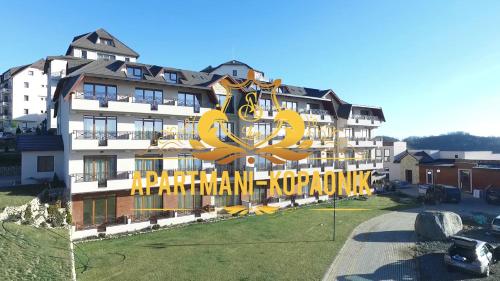 een groot gebouw met een groot geel bord erop bij As Lux Apartmani Kopaonik in Kopaonik