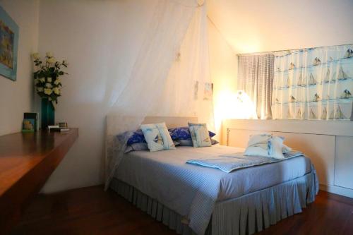 sypialnia z łóżkiem z niebieskimi poduszkami i oknem w obiekcie a casa di Marzia w mieście Reggio nell'Emilia