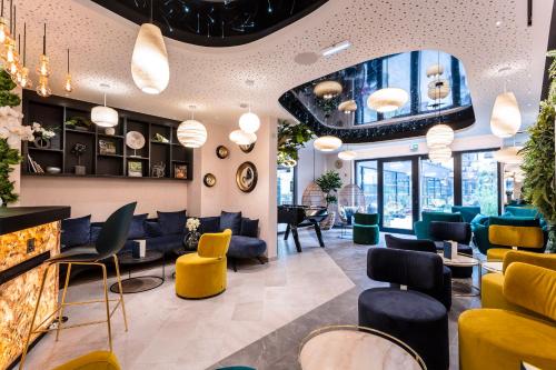 a waiting room with yellow and blue chairs at voco Strasbourg Centre - The Garden by IHG in Strasbourg