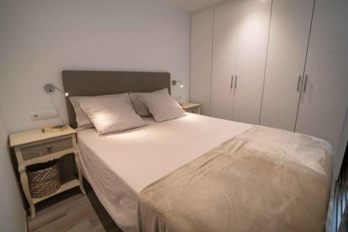 a small bedroom with a bed and a night stand at Apartament Cortey in Calella de Palafrugell