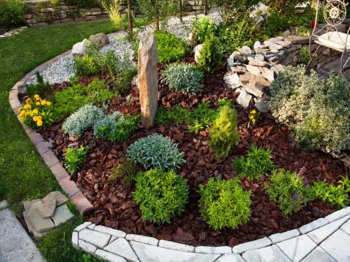 a garden with a stone circle with plants at Lichtenstein LVA Apartmán in Břeclav
