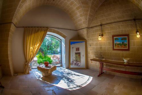 una camera con una grande finestra e un muro in pietra di Masseria La Brunetta a Massafra