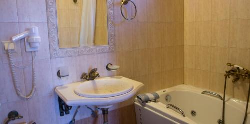 a bathroom with a sink and a bath tub at Archontiko Lydia Lithos in Órma