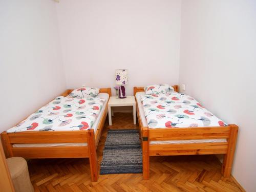 two twin beds in a room with a table at Studio apartman Rest Nest in Čakovec