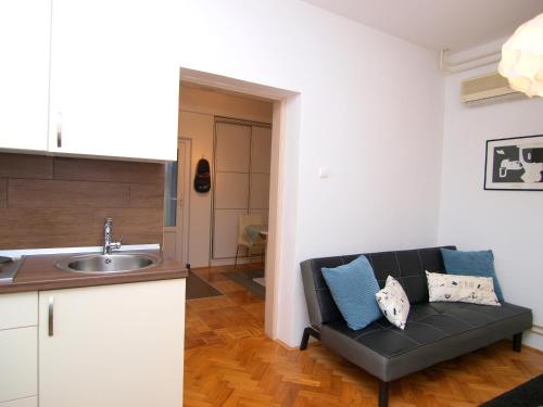 un soggiorno con divano e una cucina di Studio apartman Rest Nest a Čakovec