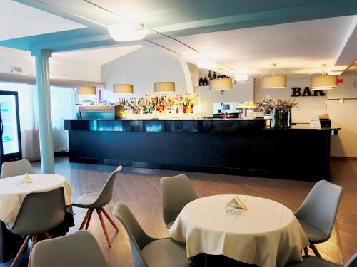 a restaurant with two tables and chairs and a bar at Loano 2 Village in Loano
