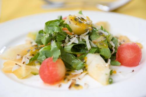 a salad on a white plate on a table at Young Island Resort in Kingstown
