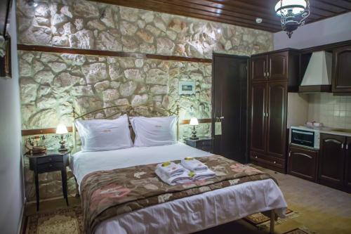 a bedroom with a bed and a stone wall at Archontiko Lydia Lithos in Órma