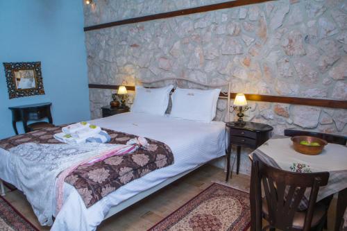 a bedroom with a bed and a stone wall at Archontiko Lydia Lithos in Órma