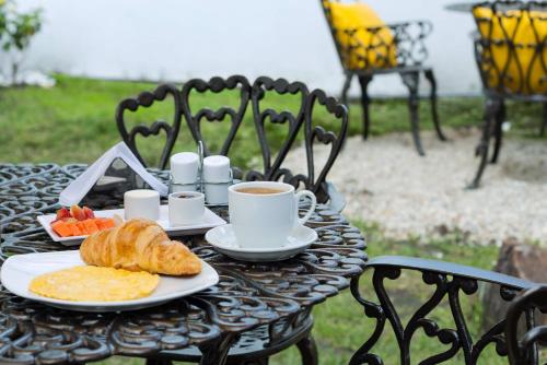 una mesa con una taza de café y un plato de comida en Hotel Normandia Gold, en Bogotá