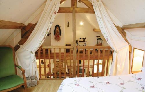 a bedroom with a bed and a green chair at la roseraie in Caumont