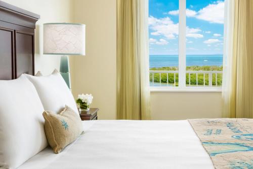 a bedroom with a bed with a view of the ocean at 24 North Hotel Key West in Key West