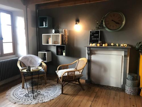 - un salon avec deux chaises et une horloge murale dans l'établissement Maison avec vue, à Pouldouran