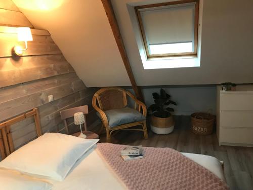 une chambre avec un lit, une chaise et une fenêtre dans l'établissement Maison avec vue, à Pouldouran
