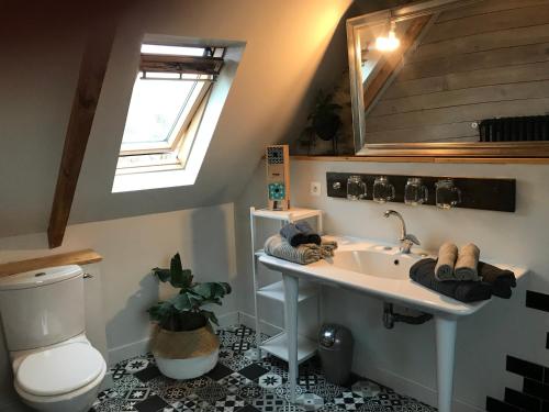 une salle de bain avec un lavabo, des toilettes et un miroir dans l'établissement Maison avec vue, à Pouldouran