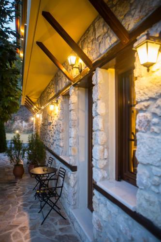 a stone building with a table and chairs on a patio at Archontiko Lydia Lithos in Órma