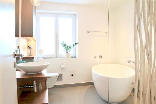 a bathroom with two sinks and a glass shower at Boutique Hotel Reschen in Tutzing