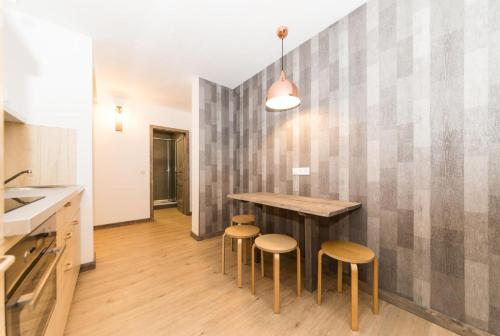 a kitchen with a wooden table and stools at L-DOM in Metzingen