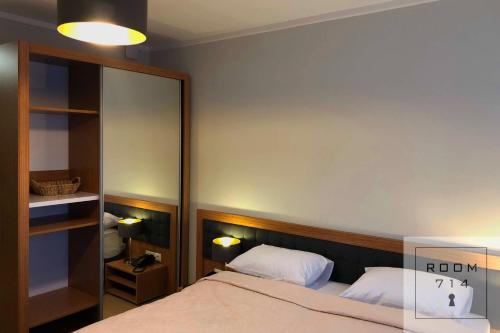 1 dormitorio con cama y espejo grande en ORBI Palace Deluxe, en Bakuriani