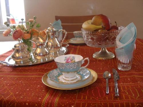 un tavolo con tazze da tè e un cesto di frutta di AL PONTEROSSO a Trieste