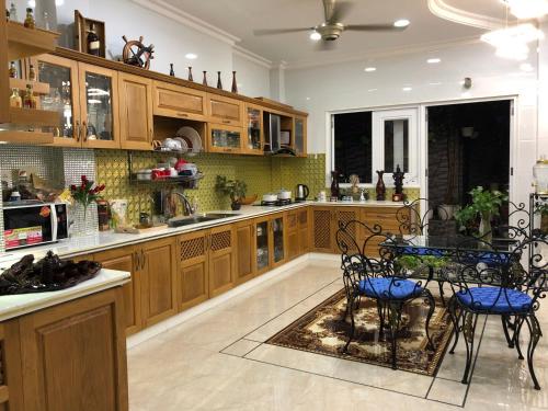 a kitchen with wooden cabinets and a table and chairs at The Moana House in Ho Chi Minh City