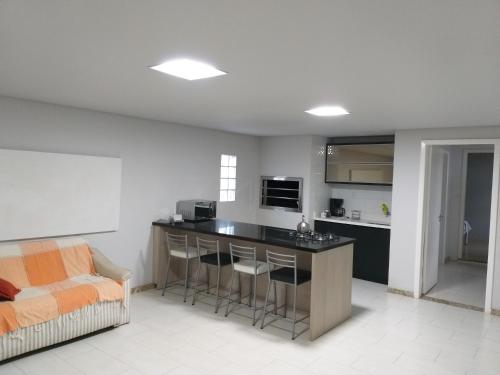 a living room with a kitchen with a bar and a couch at Norte Hospedagem in Lages