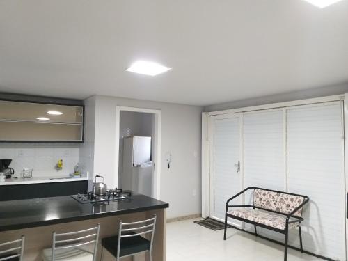 a kitchen with a counter and a chair in it at Norte Hospedagem in Lages