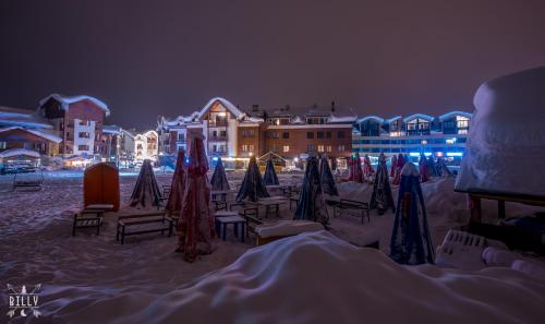 a beach with chairs and umbrellas in the snow at night at New Gudauri-Loft II-Near Gondola in Gudauri