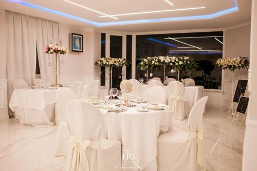 a wedding reception with white tables and chairs at Guardanapoli in Cervino