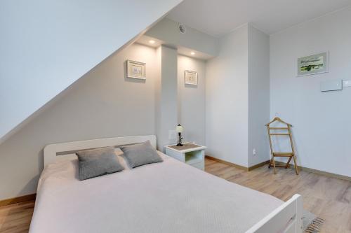 - une chambre avec un lit blanc et une échelle dans l'établissement Apartament Sopocki Kasztanowy, à Sopot