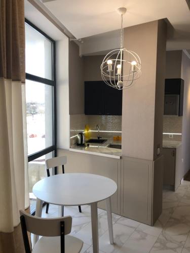 a kitchen with a table and chairs and aendant light at Motel Kurortnyy & SPA in Shklo